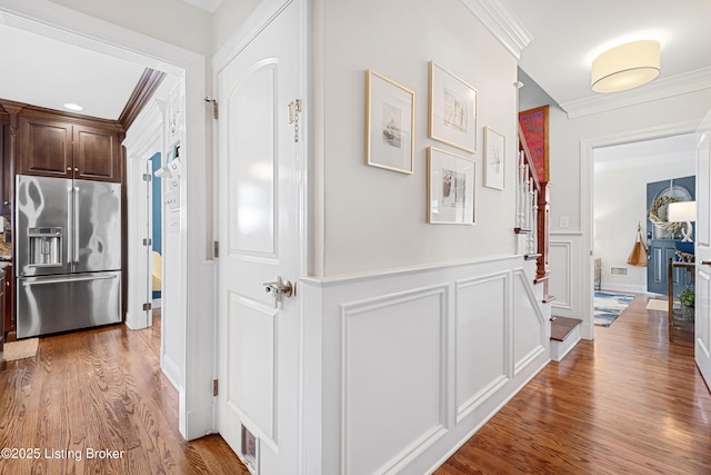 hallway with hardwood / wood-style floors and ornamental molding