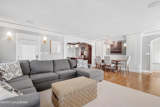 living room with light wood-type flooring and crown molding