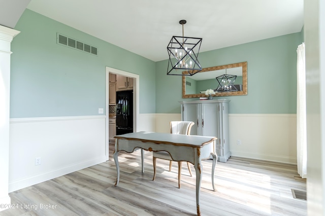 dining space featuring light hardwood / wood-style flooring and a notable chandelier