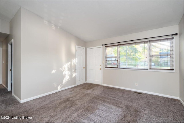 unfurnished room with dark carpet