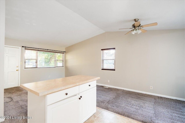 kitchen with white cabinets, ceiling fan, light colored carpet, and vaulted ceiling