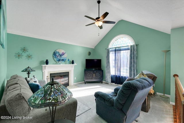 living room featuring light carpet, vaulted ceiling, a tile fireplace, and ceiling fan