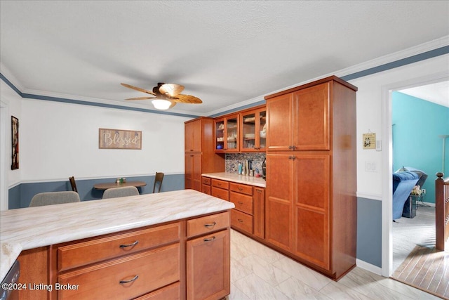 kitchen with crown molding, ceiling fan, and decorative backsplash