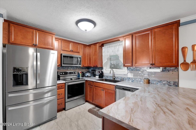 kitchen featuring stainless steel appliances, sink, a textured ceiling, and decorative backsplash