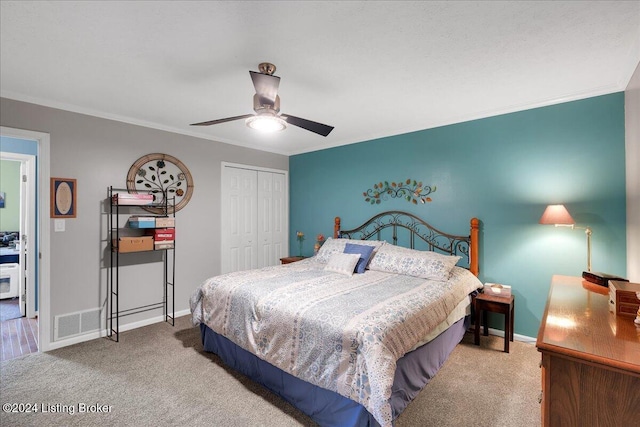 bedroom with ornamental molding, light carpet, ceiling fan, and a closet