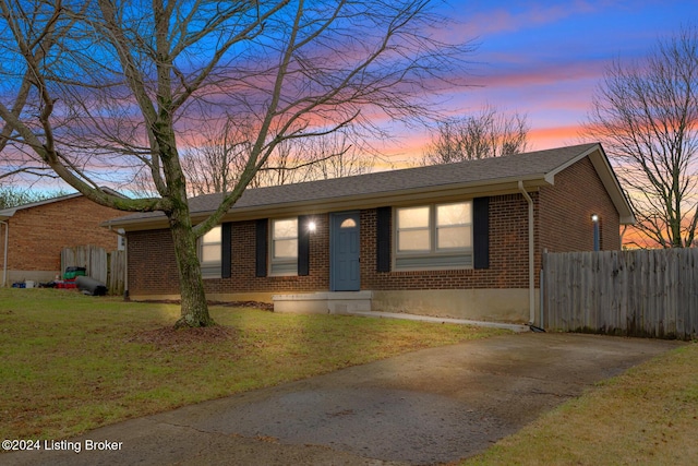 single story home featuring a lawn