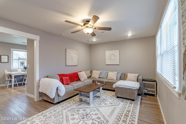 living room with light wood-type flooring and ceiling fan