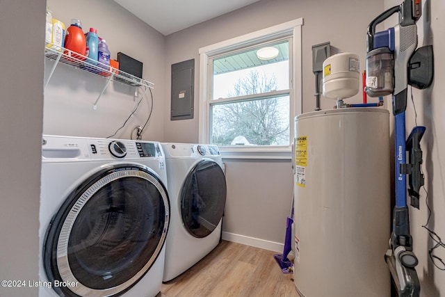 clothes washing area with electric panel, water heater, washer and dryer, and light hardwood / wood-style floors