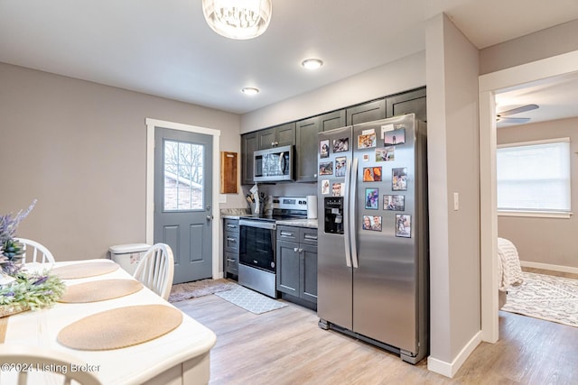 kitchen featuring ceiling fan, a healthy amount of sunlight, stainless steel appliances, and light hardwood / wood-style flooring