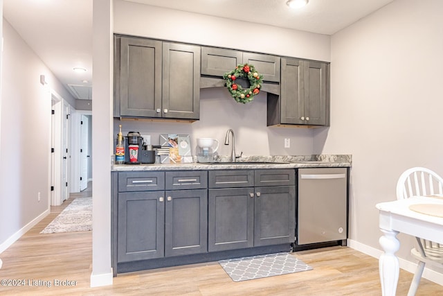 kitchen featuring gray cabinetry, sink, stainless steel dishwasher, light stone countertops, and light wood-type flooring