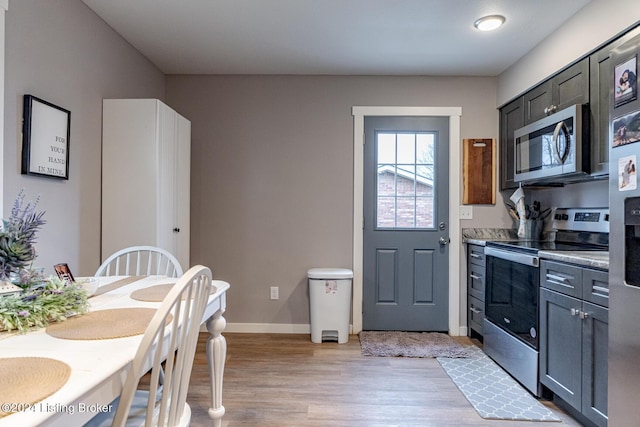 kitchen featuring gray cabinets, light hardwood / wood-style floors, and appliances with stainless steel finishes