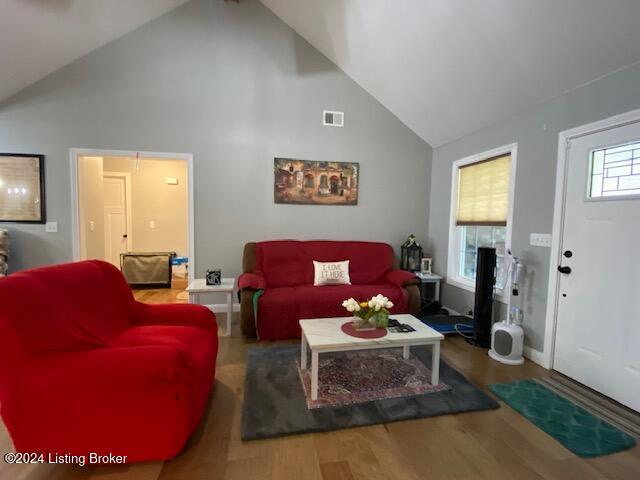 living room with high vaulted ceiling and wood-type flooring