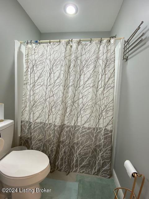 bathroom featuring a shower with shower curtain and toilet