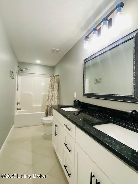 bathroom with double vanity, toilet, visible vents, and a sink