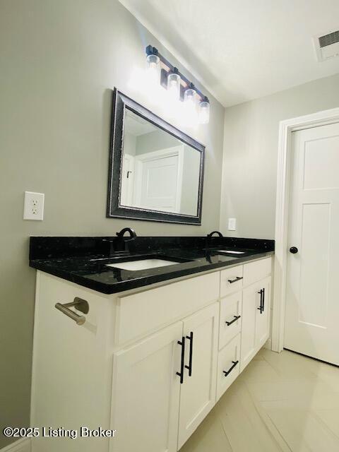 bathroom featuring double vanity, visible vents, and a sink