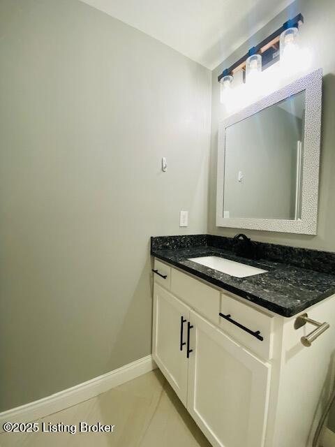 bathroom with vanity, baseboards, and tile patterned flooring