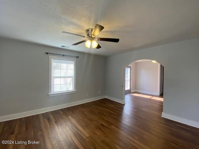 spare room featuring ceiling fan, dark hardwood / wood-style flooring, and a textured ceiling