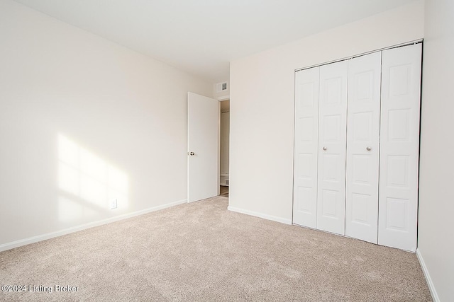 unfurnished bedroom with carpet flooring and a closet