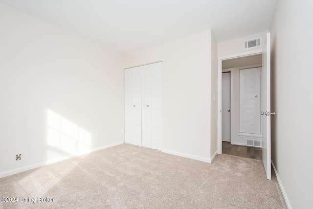 unfurnished bedroom featuring carpet and a closet