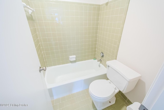 bathroom with tile patterned flooring, tiled shower / bath combo, and toilet