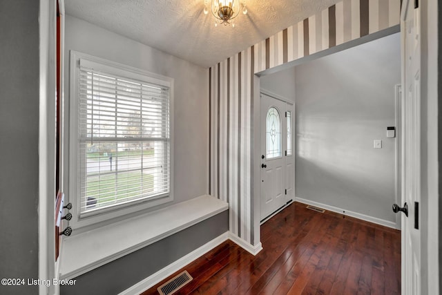 foyer with a textured ceiling and dark hardwood / wood-style flooring