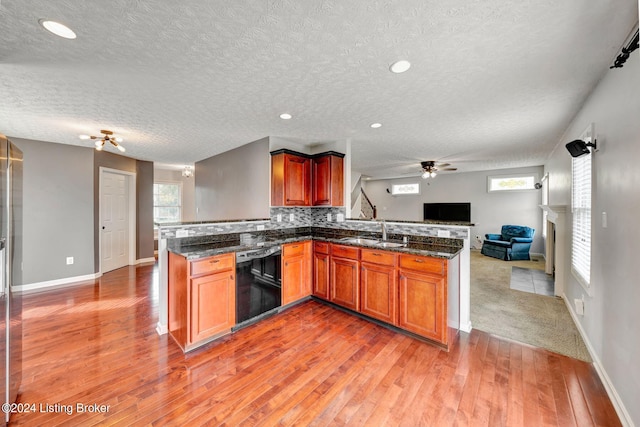 kitchen featuring kitchen peninsula, hardwood / wood-style floors, a textured ceiling, and dishwasher