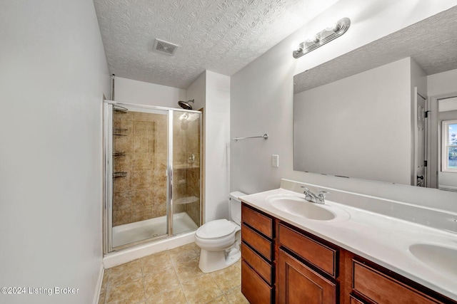 bathroom featuring vanity, tile patterned floors, toilet, a textured ceiling, and an enclosed shower