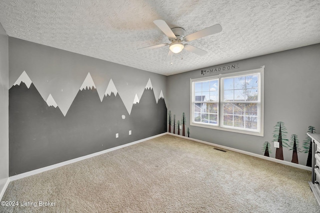 unfurnished room with carpet flooring, ceiling fan, and a textured ceiling