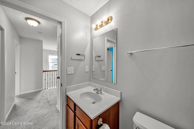 bathroom with vanity, a textured ceiling, and toilet