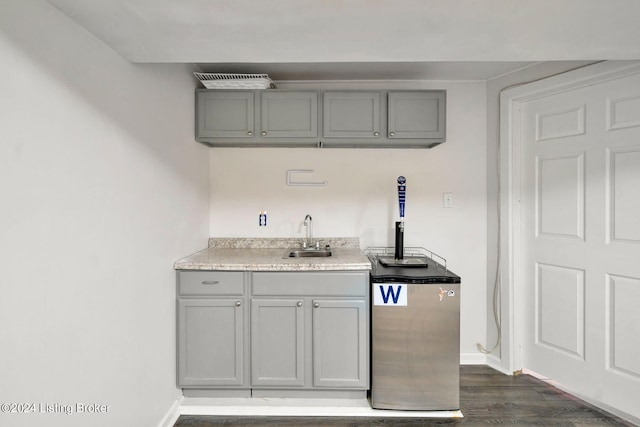 kitchen with gray cabinetry, dark hardwood / wood-style flooring, and sink