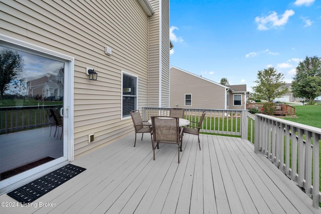 wooden terrace featuring a lawn