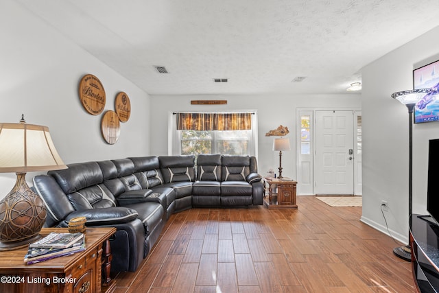 living room with hardwood / wood-style floors and a textured ceiling