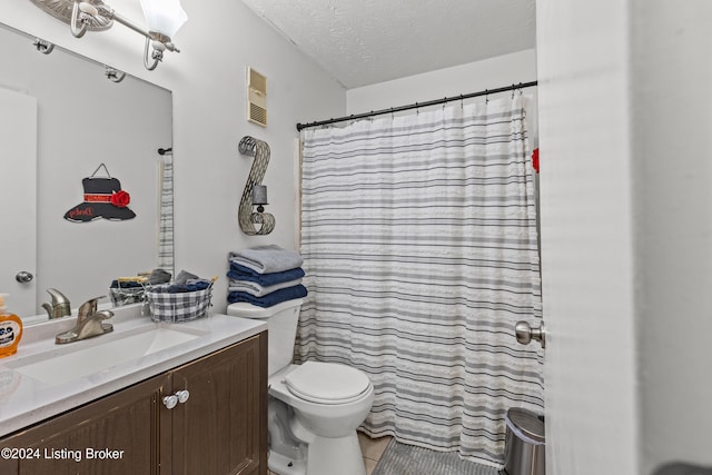 bathroom with tile patterned flooring, vanity, a textured ceiling, and toilet