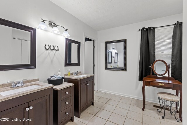 bathroom with a textured ceiling, vanity, and tile patterned floors