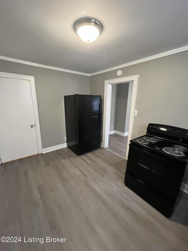 kitchen with crown molding, black appliances, and light hardwood / wood-style floors