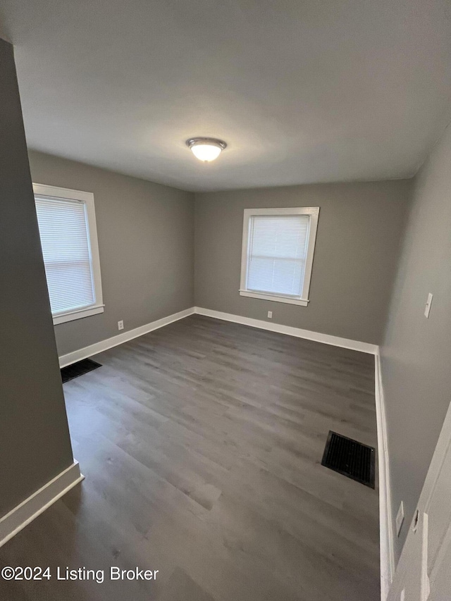 empty room with dark hardwood / wood-style flooring