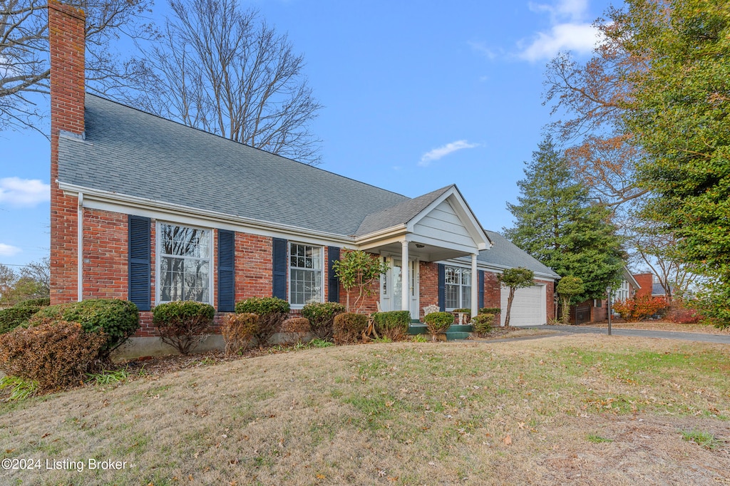 view of front of house featuring a garage and a front lawn