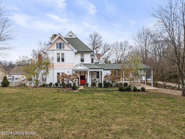 view of front of house with a front yard, a carport, and covered porch