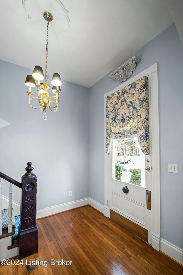 unfurnished dining area with dark wood-type flooring and a notable chandelier