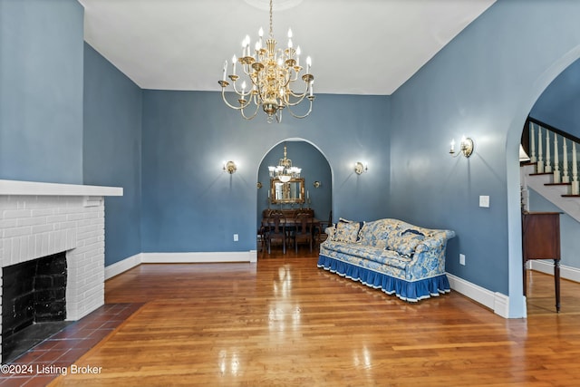 living area featuring a fireplace, a chandelier, and hardwood / wood-style flooring