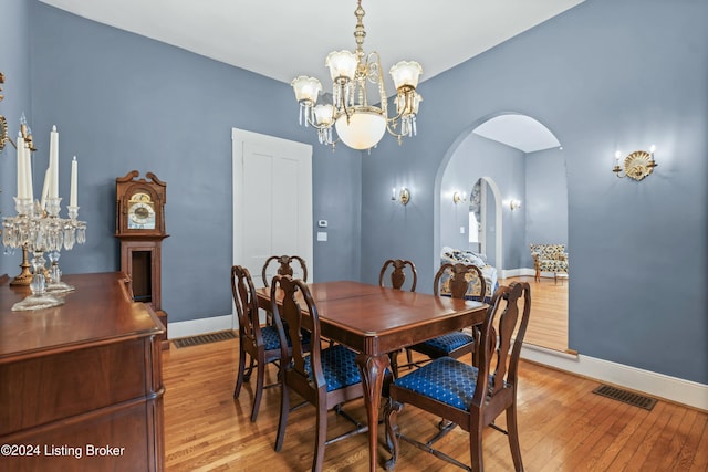 dining area featuring light wood-type flooring and a chandelier