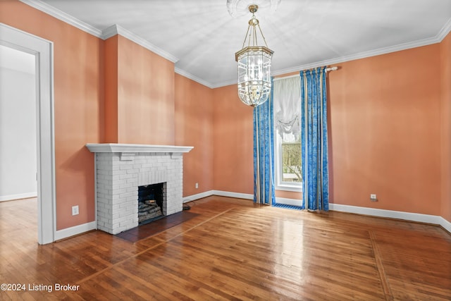 unfurnished living room featuring crown molding, dark hardwood / wood-style floors, a notable chandelier, and a brick fireplace