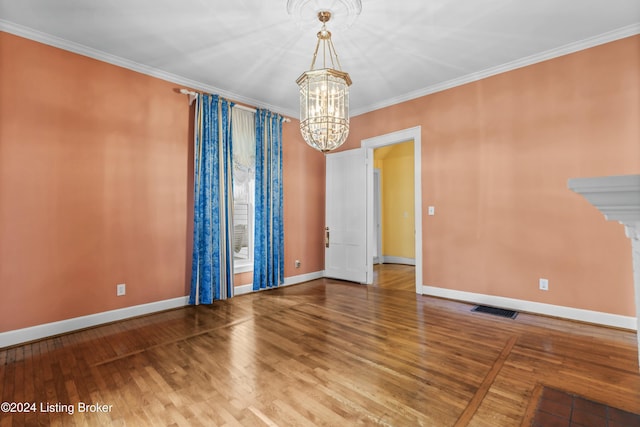 unfurnished room with wood-type flooring, ornamental molding, and an inviting chandelier