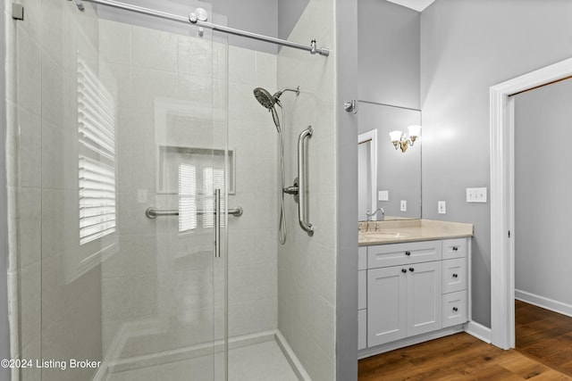 bathroom featuring hardwood / wood-style floors, vanity, and a shower with door