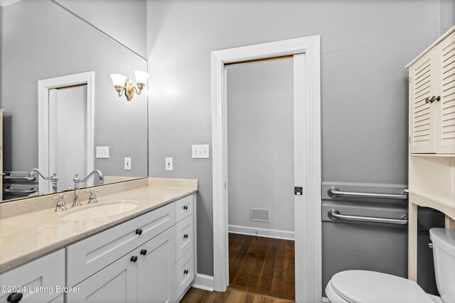 bathroom featuring vanity, hardwood / wood-style flooring, and toilet