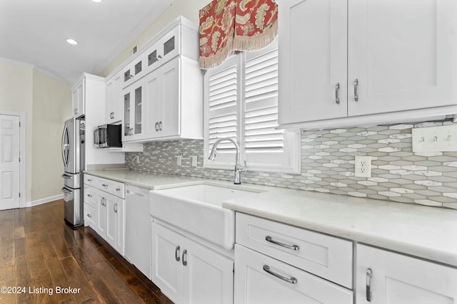 kitchen with dishwasher, sink, decorative backsplash, stainless steel fridge, and white cabinetry