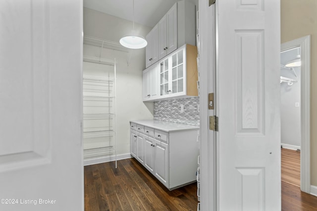 kitchen featuring white cabinets, dark hardwood / wood-style floors, and backsplash