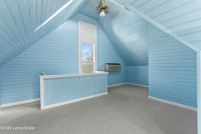 additional living space featuring light colored carpet and a wall mounted air conditioner