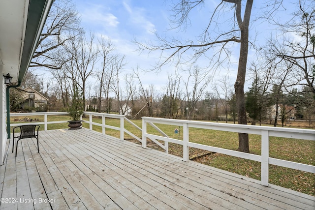 wooden terrace featuring a lawn