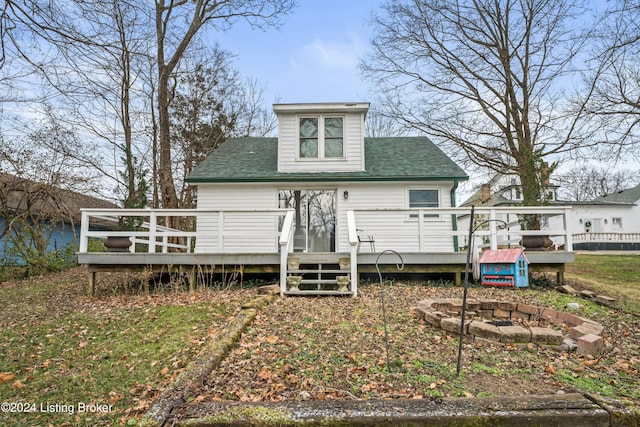 back of property with a fire pit and a deck